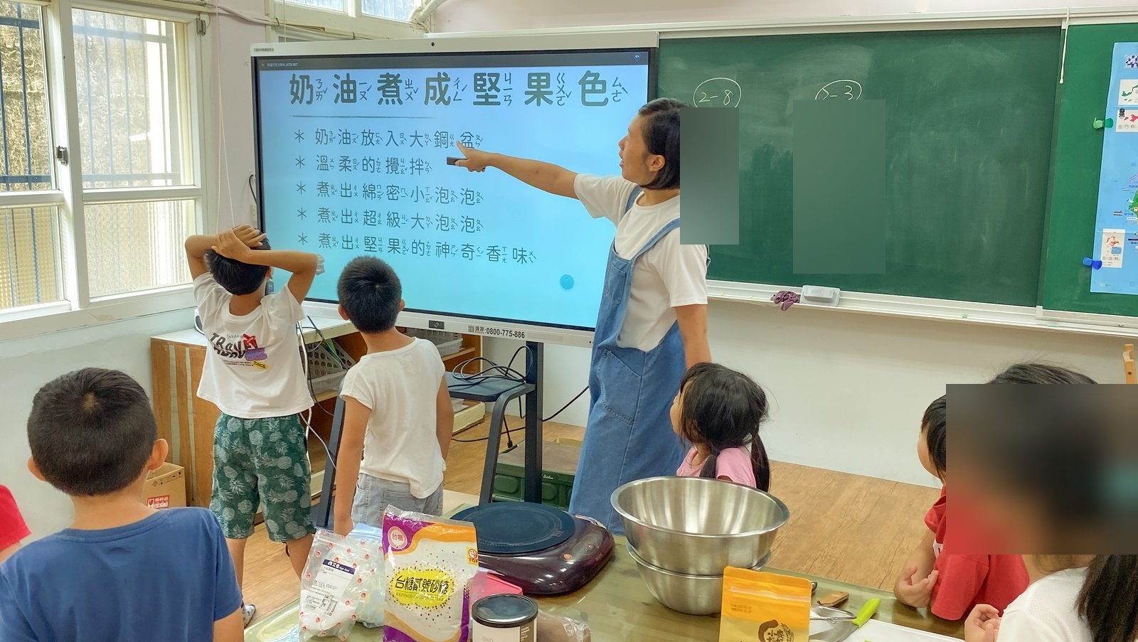 講師站在投影幕前,指著「奶油煮成堅果色」的步驟,孩子圍在前方聽