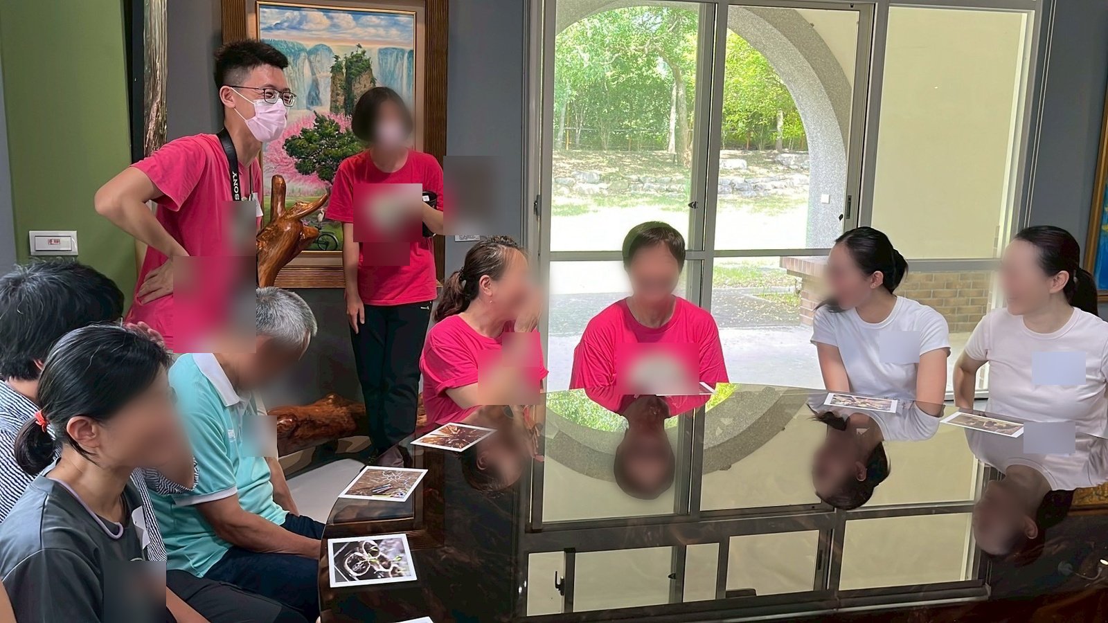 學員圍著長桌坐,桌上擺著圖卡,大家看著其中一位說話